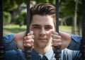 Attractive young man behind bars of metal gate Royalty Free Stock Photo