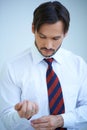 Attractive young man doing up his shirt cuffs Royalty Free Stock Photo