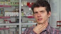 Handsome young man coughing having sore throat standing at the pharmacy Royalty Free Stock Photo