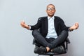 Attractive young man in glasses meditating on office chair Royalty Free Stock Photo