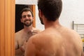 attractive young man grooming shaving trim beard on the mirror, shirtless man with skin stain or mole, i feel so happy in my skin Royalty Free Stock Photo