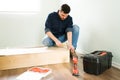 Hispanic man hammering a nail in new furniture Royalty Free Stock Photo