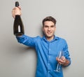 Attractive young man holding a bottle of champagne Royalty Free Stock Photo