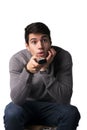 Attractive young man holding remote control and changing TV channels Royalty Free Stock Photo