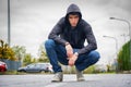 Attractive young man with hoodie and baseball cap in city street