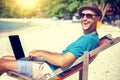 Attractive young man with laptop working on the beach. Freedom, Royalty Free Stock Photo