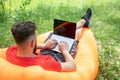 Attractive young man with laptop working on beach. Freedom, remote work, freelancer, travel and vacation concepts Royalty Free Stock Photo