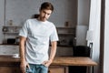 Attractive young man leaning back on kitchen table and looking at camera Royalty Free Stock Photo