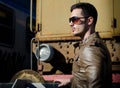 Attractive young man in leather jacket and jeans next to old train Royalty Free Stock Photo