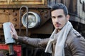Attractive young man in leather jacket and jeans next to old train Royalty Free Stock Photo