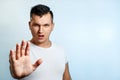 Attractive young man makes frightened gesture with palms, defends himself from someone, asks to stop it immediately. Hispter guy Royalty Free Stock Photo