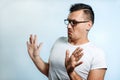 Attractive young man makes frightened gesture with palms, defends himself from someone, asks to stop it immediately. Hispter guy Royalty Free Stock Photo