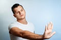 Attractive young man makes frightened gesture with palms, defends himself from someone, asks to stop it immediately. Hispter guy Royalty Free Stock Photo