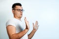 Attractive young man makes frightened gesture with palms, defends himself from someone, asks to stop it immediately. Hispter guy Royalty Free Stock Photo