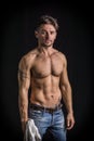 Attractive young man with naked muscular torso, wearing jeans