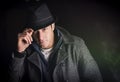 Attractive young man at night, wearing winter coat and fedora hat Royalty Free Stock Photo