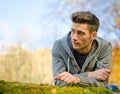 Attractive young man outdoors in nature lying on moss Royalty Free Stock Photo