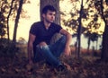 Attractive young man in park resting against tree Royalty Free Stock Photo