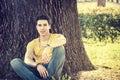 Attractive young man in park resting against tree Royalty Free Stock Photo