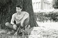 Attractive young man in park resting against tree Royalty Free Stock Photo