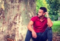 Attractive young man in park resting against tree Royalty Free Stock Photo