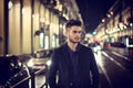 Attractive young man portrait at night with city lights