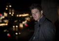 Attractive young man portrait at night with city lights behind him Royalty Free Stock Photo