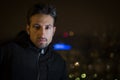 Attractive young man portrait at night with city lights behind him Royalty Free Stock Photo