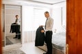 attractive young man poses as a groom before the wedding, putting on a jacket Royalty Free Stock Photo