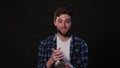 A young man mimicing against a black background