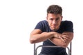 Attractive young man sitting, leaning on back of a chair Royalty Free Stock Photo