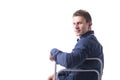 Attractive young man sitting, leaning on back of a Royalty Free Stock Photo