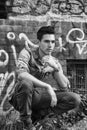 Attractive young man sitting outdoor in front of abandoned house Royalty Free Stock Photo