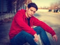 Attractive young man sitting on street curb Royalty Free Stock Photo