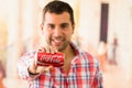 Attractive young man smiling holding a Coca-Cola