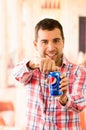 Attractive young man smiling opening a Pepsi Cola