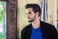 Attractive young man standing against brick wall