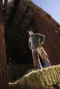 Attractive Young Man Standing on a Bale of Hay Royalty Free Stock Photo