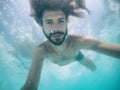 Attractive young man submerged in pool looking at camera Royalty Free Stock Photo