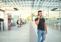 Attractive young man in train station using cellphone