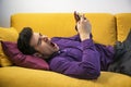 Attractive young man using cell phone and yawning Royalty Free Stock Photo