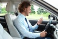 Attractive young man using phone while driving his car Royalty Free Stock Photo