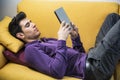 Attractive young man using tablet PC while laying Royalty Free Stock Photo