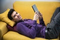 Attractive young man using tablet PC while laying Royalty Free Stock Photo