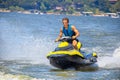 - Attractive young man on wave runner - PWC - jet ski crouched and leaning forward as he prepares Royalty Free Stock Photo