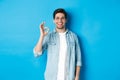 Attractive young man wearing glasses and casual clothes, showing ok good sign in approval, like something, standing Royalty Free Stock Photo