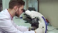 Man looking through the microscope at the laboratory Royalty Free Stock Photo