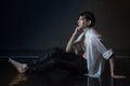 Attractive young man in white wet clothes in small pool under drops of the rain. Studio photo Royalty Free Stock Photo