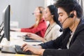 Attractive young man working in a call center with his colleagues Royalty Free Stock Photo