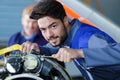 Attractive young mechanic wearing overalls looking at camera Royalty Free Stock Photo